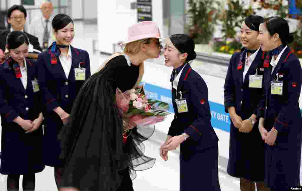 Singer Lady Gaga kisses a Japan Airlines (JAL) staff upon her arrival at Narita International airport in Narita.