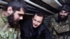 FILE - Syrian President Bashar al-Assad, center, speaks with Syrian troops during his visit to the front line in the eastern Damascus district of Jobar, Dec. 31, 2014.