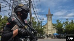 An Indonesian policeman stands guard outside a church after an explosion in Makassar, March 28, 2021.