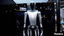 资料照片：特斯拉机器人于2023年7月6日在中国上海举行的世界人工智能大会(WAIC)上展示。官媒新华社10月2日表示将出台支持政策，持续推动中国智能网联汽车产业高质量发展。中国智能汽车行业面临着地缘政治阻力以及来自特斯拉等西方同行在改进技术方面的激烈竞争。 (路透社图片)