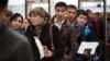 FILE - Migrants stand in line to register at Moscow's migration center in Sakharovo, a village about 60 kilometers (35 miles) south of Moscow, Russia, April 22, 2015. 