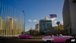 Wisatawan mengendarai mobil klasik Amerika Convertible melewati Kedutaan Besar Amerika Serikat di Havana, Cuba, 12 Januari 2017. Kanada melaporkan salah seorang diplomatnya di Havana mengalami insiden yang mengakibatkan kehilangan pendengaran, sama seperti yang dialami beberapa diplomat Amerika.