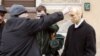 Seorang polisi berpakaian sipil Rusia berusaha melepas topeng yang menampilkan Presiden Vladimir Putin dari seorang demonstran di pusat kota St. Petersburg, 28 Februari 2004. (REUTERS/Alexander Demianchuk)