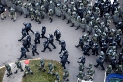Belarusian riot police block the road to stop demonstrators during an opposition rally to protest the official presidential election results in Minsk, Belarus, Nov. 15, 2020.