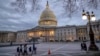 FILE - People walk by the U.S. Capitol in Washington, Jan. 21, 2018, as lawmakers prepare to vote on a spending bill that would fund U.S. government operations for the remainder of the current fiscal year which ends Sept. 30.