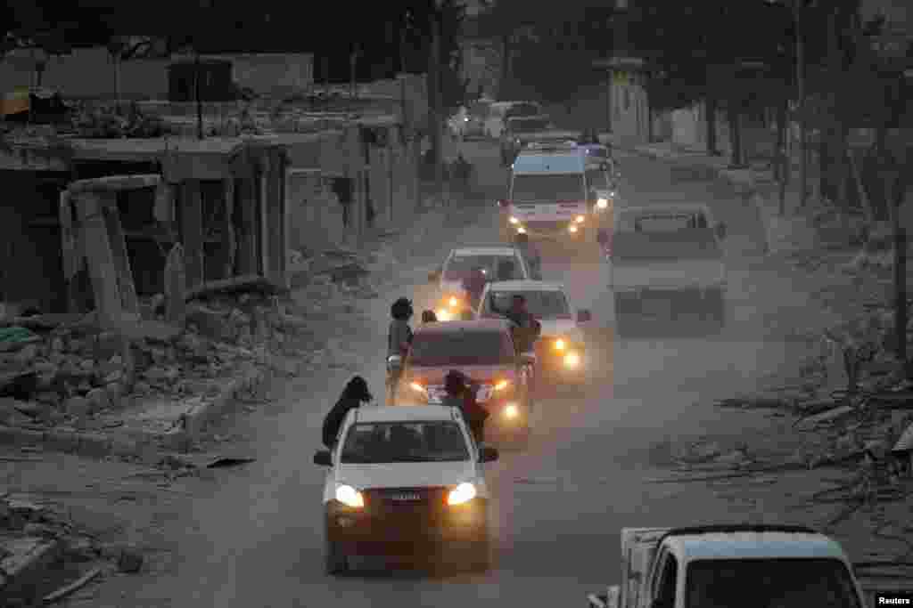 Rebel fighters drive their vehicles celebrating what they said was the taking over of Baraghedeh and Kafr-Ghan towns, northern Aleppo countryside, Syria, Oct.10, 2016.