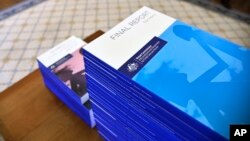 In this photo provided by the Australian Government Royal Commission, the volumes of the Final Report of the Royal Commission into Institutional Responses to Child Sexual Abuse sit on a table at Government House, in Canberra, Dec. 15, 2017.