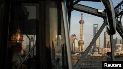 FILE - A bus moves past a bridge with the backdrop of the financial district of Pudong in Shanghai, China, Sept. 27, 2024