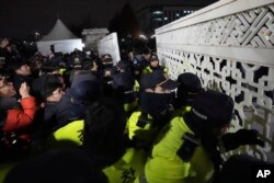 Para pedemo mencoba memasuki kompleks parlemen yang dihalangi oleh para polisi di Seoul, Korea Selatan, Selasa, 3 Desember 2024. (Foto: Lee Jin-man/AP Photo)