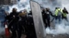 Protesters wearing yellow vests, a symbol of a French drivers' protest against higher fuel prices, clash with riot police on the Champs-Elysee in Paris, Nov. 24, 2018.
