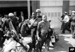 Policija hapsi sveštenika Ralfa Abernatija i Martina Lutera Kinga za vreme protesta u Birmingemu u Alabami 1963.