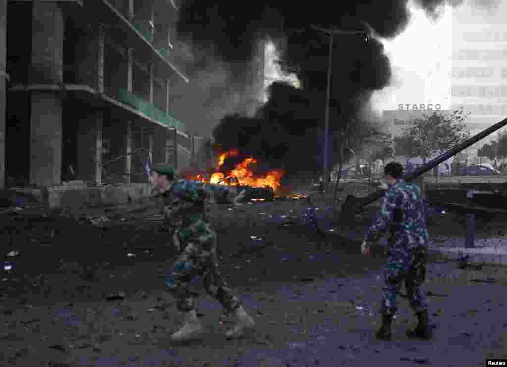 A Lebanese army soldier gestures as he runs near the site of an explosion in the downtown area of Beirut, Lebanon, Dec. 27, 2013.