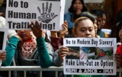 TKW memajang foto TKW Erwiana Sulistyaningsih, 23 tahun, saat melakukan aksi unjuk rasa di luar Konsulat RI di Hongkong, Kamis, 16 Januari 2014. (Foto: AP)