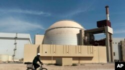 FILE - Seorang pekerja mengendarai sepeda melewati depan gedung reaktor pembangkit listrik tenaga nuklir Bushehr, Iran, 26 Oktober 2010. (AP/Mehr News Agency, Majid Asgaripour, file)