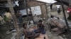 FILE - Rohingya people pass their time in a damaged shelter in Rohingya IDP camp outside Sittwe, Rakhine state, Aug. 4, 2015. Kerry noted the Rohingya as a group that has been 'singled out' for discrimination.