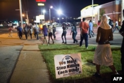 Para pengunjuk rasa menandai peringatan setahun penembakan Michael Brown, dengan pawai di sepanjang jalan West Florrisant (11/8), di Ferguson, Missouri.