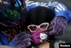 A mother adjusts her daughter's mask as they head home from school in Kertapati district in Palembang, on the Indonesian island of Sumatra, Sept. 18, 2015.
