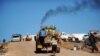 FILE - Syrian internally displaced children jump on the back of a truck at the Atme refugee camp, along the Turkish border in the northwestern Syrian province of Idlib. 