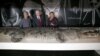 FILE - U.S. Vice President Mike Pence, center, observes a life-size replica of an Australian saltwater crocodile during his visit to the Australian Museum with Australian Foreign Minister Julie Bishop, left, and the museum's Executive Director Kim McKay in Sydney, Australia, April 22, 2017.