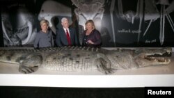 FILE - U.S. Vice President Mike Pence, center, observes a life-size replica of an Australian saltwater crocodile during his visit to the Australian Museum with Australian Foreign Minister Julie Bishop, left, and the museum's Executive Director Kim McKay in Sydney, Australia, April 22, 2017.