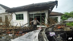Seorang polisi memeriksa rumah seorang warga Ahmadiyah yang dirusak oleh massa di Pandeglang, Banten dalam insiden tahun 2011 (foto: ilustrasi).