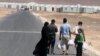 A Syrian refugee family walks towards the new Syrian camp of Azraq, which stretches for 15 kilometers, and lies about 100 kilometers from the Syrian border in Jordan, Wednesday, April 30, 2014.