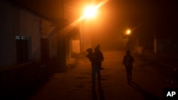 FILE - A migrant woman and two children begin their walk north from the community of La Lima in southern Veracruz state, Mexico, Nov. 24, 2021. 