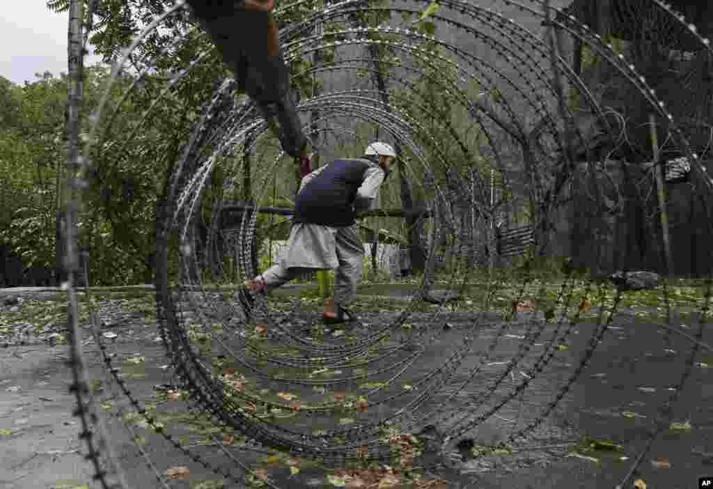 A man ducks to cross a barricade near a military base at Braripora, in Indian-controlled Kashmir.