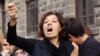 Emel Kitapci, the wife of Ali Kitapci, one of the victims from Saturday's bomb attacks, reacts as she stands with her son Artun Siyah Kitapci, 11, during a demonstration at the site of the explosions, in Ankara, Turkey, Oct. 12, 2015. 