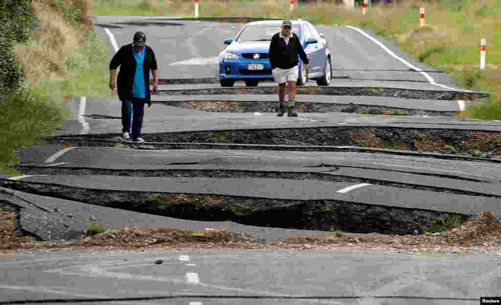 Local residents Chris and Viv Young look at damage caused by an earthquake, along State Highway One near the town of Ward, south of Blenheim on New Zealand's South Island.