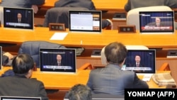 Para legislator Korea Selatan menyaksikan layar televisi yang menyajikan tayangan Presiden Korea Selatan Yoon Suk Yeol mengumumkan akan mencabut status darurat militer, Rabu, 4 Desember 2024. (Foto: Yonhap/AFP)