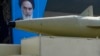 A missile is carried on a truck in front of a portrait of the late Iranian revolutionary founder Ayatollah Khomeini during an annual armed forces parade, just outside Tehran, Iran, Sept. 21, 2024.