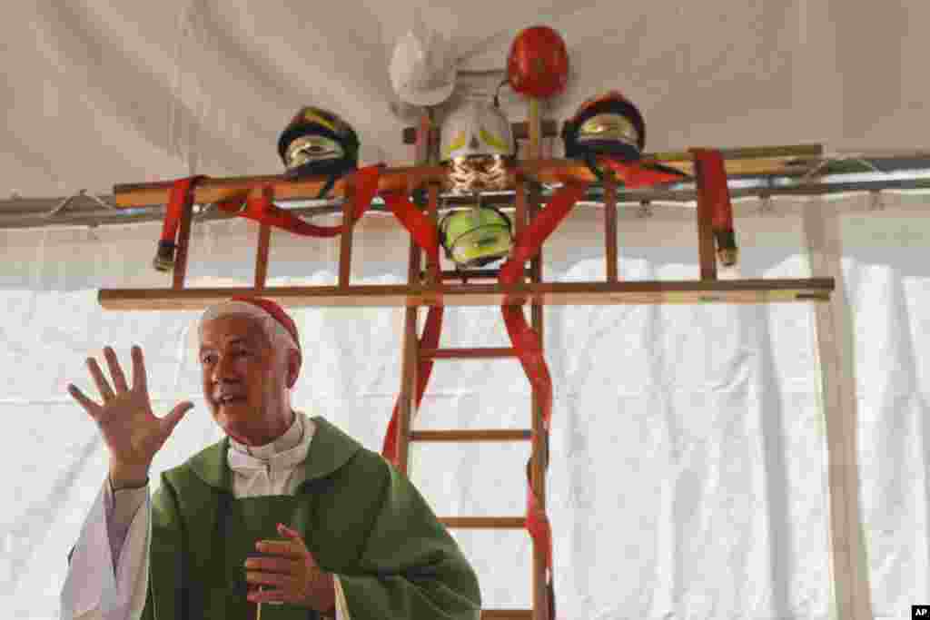 A cross made with ladders and firefighter helmets is placed inside a tent during a Mass celebrated by Bishop Giovanni D'Ercole, in Arquata Del Tronto, near Amatrice, central Italy. The tent was set up as a temporary shelter for the earthquake survivors.