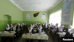FILE - Class 11 Afghan girl students attend a class at Zarghona high school in Kabul, Afghanistan, Aug. 15, 2015. 