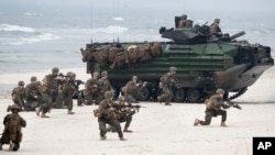FILE - U.S. Marines with Amphibious Assault Vehicles take a part in a landing operation during a military Exercise Baltops 2018 at the Baltic Sea, some 340 kms (211 miles) west north of the capital Vilnius, Lithuania, June 4, 2018.