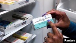 FILE - A doctor points to a measles, mumps and rubella vaccine — also known as an MMR vaccine — during a measles outbreak in Lubbock, Texas, March 6, 2025. 