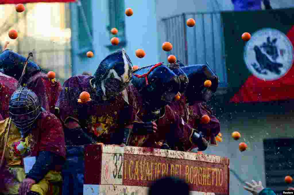 Warga ikut serta dalam pertarungan saling lempar jeruk (Perang Jeruk) selama pertarungan karnaval tahunan di Ivrea, Italia. (Reuters) 