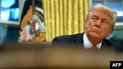 U.S. President Donald Trump looks up after signing an executive order in the Oval Office of the White House in Washington, Feb. 10, 2025.