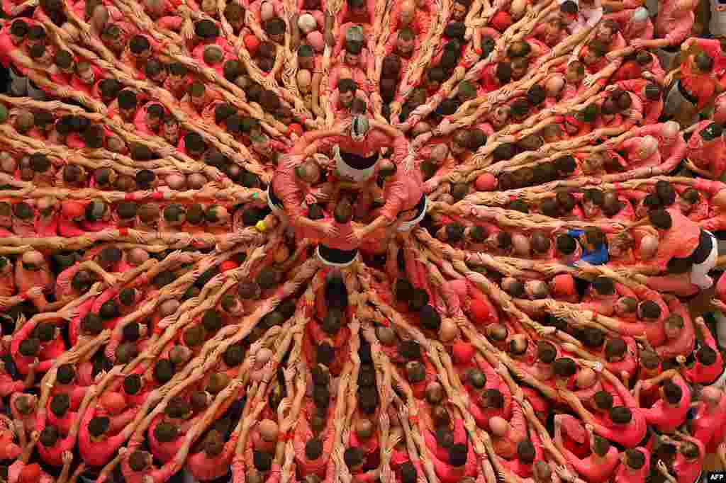 Members of the "Colla Vella dels Xiquets de Valls" human tower team form a "castell" (human tower) during the XXVI human towers competetion in Tarragona, Spain.