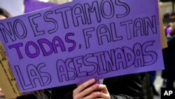 Seorang perempuan menunjukkan poster dalam unjuk rasa menentang kekerasan terhadap perempuan di Pamplona, Spanyol utara, 8 Maret 2020.