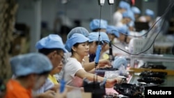 Employees work on the production line of a robot vacuum cleaner factory of Matsutek in Shenzhen, China, Aug. 9, 2019.