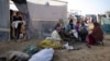 Anggota keluarga Abu Jarad, yang mengungsi akibat pemboman Israel di Jalur Gaza, memanggang roti di tenda kamp darurat di daerah Muwasi, Gaza selatan. 