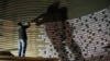 FILE - A worker installs names of the victims of the 2004 Indian Ocean tsunami on the wall of the Tsunami Museum ahead of the 10th anniversary of the killer waves in Banda Aceh, Aceh province, Indonesia, Dec. 4, 2014. The 20th anniversary will be observed on Dec. 26 this year.