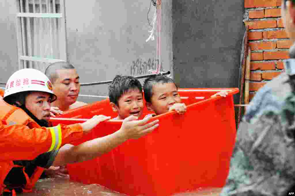 Rescuers evacuate flood-affected children in Ningde, eastern China's Fujian province. Typhoon Megi smashed into the Chinese mainland, killing one person, after leaving a trail of destruction and four people dead in Taiwan.