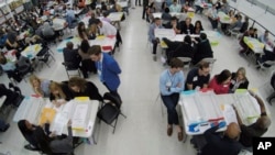 ARSIP – Foto bertanggal 16 November 2018 di KPUD Broward County menunjukkan kertas suara ke masing-masing perwakilan Partai Republik dan Demokrat dalam penghitungan manual di Lauderhill, Florida (foto: AP Photo/Wilfredo Lee, Arsip)
