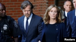 Aktris AS Felicity Huffman (kanan) meninggalkan pengadilan bersama suaminya, William H. Macy, setelah menerima vonis 14 hari hukuman penjara di Boston, Massachusetts, Jumat (13/9). 