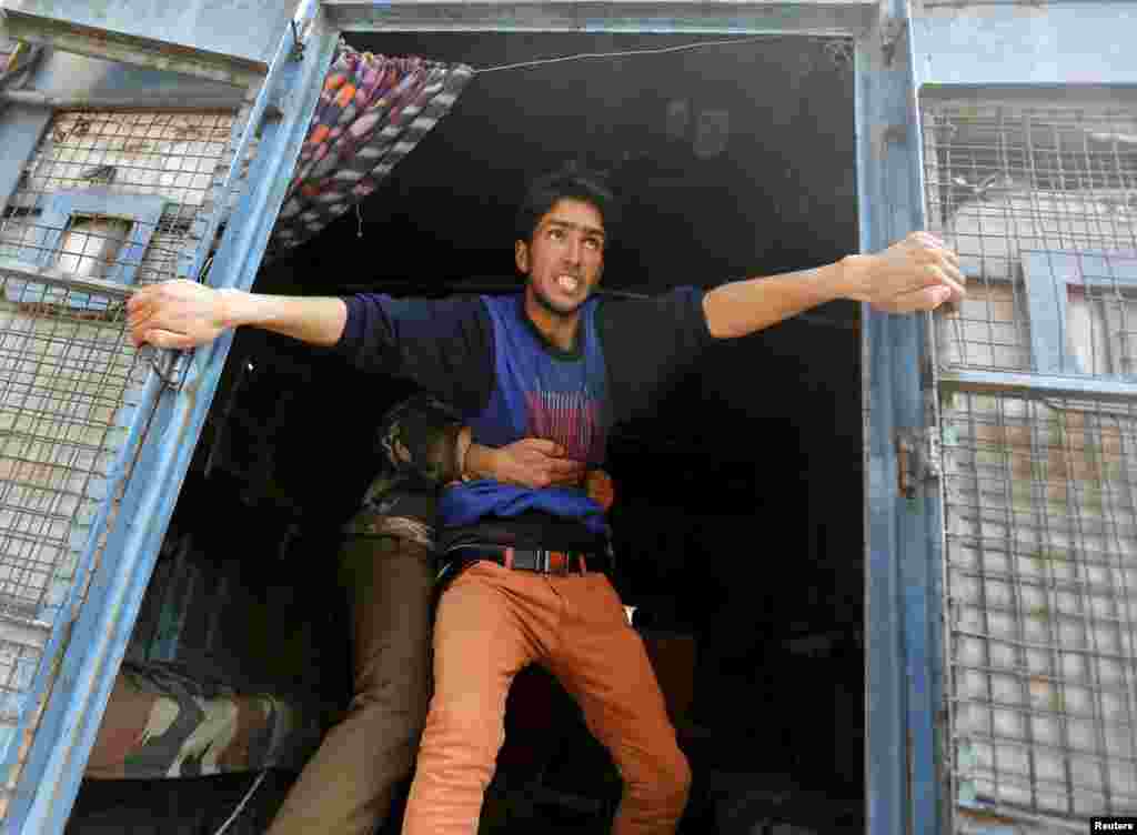 A supporter of Kashmiri lawmaker Sheikh Abdul Rashid, also known as Engineer Rashid, attempts to jump from a police vehicle after he was detained by Indian police during a protest in Srinagar, India. Dozens of supporters of Rashid were detained by police during a protest against the arrest of former Delhi University lecturer (SAR) Syed Abdul Rehman Geelani and also against the deaths of two youths in south Kashmir's Pulwama district, protesters said.