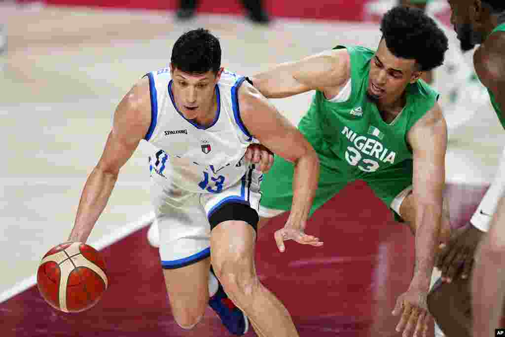 Italy's Simone Fontecchio (13), left, drives around Nigeria's Jordan Nwora (33), right, during men's basketball preliminary round game at the 2020 Summer Olympics, Saturday, July 31, 2021, in Saitama, Japan. (AP Photo/Charlie Neibergall)