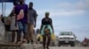 Seseorang membawa kontainer berisi bensin untuk dijual di jalanan Cap-Haitien, Haiti, 29 April 2024. (Foto: REUTERS/Ricardo Arduengo)