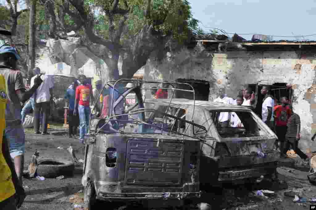Mutane sun taru kusa da inda bam ya tashi cikin mota a kasuwar "Monday Market" ta Maiduguri, talata 1 Yuli, 2014. Mutane da dama sun mutu, akasarinsu mata tsoffi da almajirai dake bara.